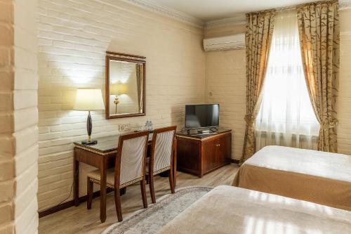 a hotel room with a bed and a desk and a television at SAMIR HOTEL in Yakkasaray