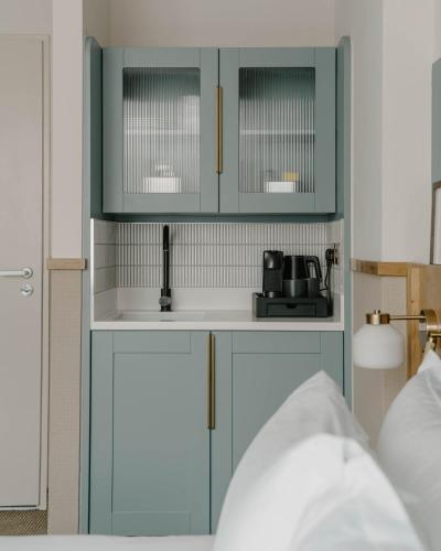 a kitchen with blue cabinets and a sink at Club Quarters Hotel St Paul's, London in London