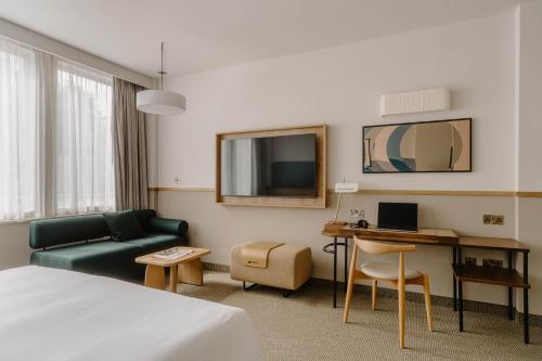 a hotel room with a bed and a couch and a desk at Club Quarters Hotel St Paul's, London in London