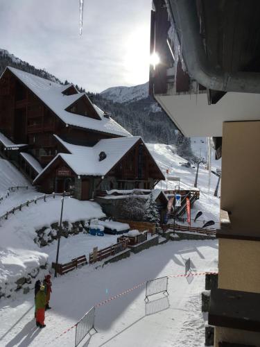 a group of people standing in the snow near a ski lodge at Superbe appartement 8 personnes au pied des pistes in Oz
