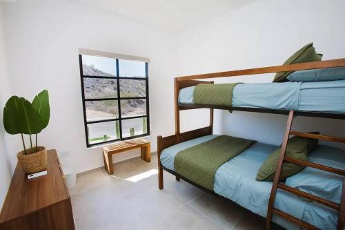 a room with two bunk beds and a window at Exclusive pool house in Bahía Kino
