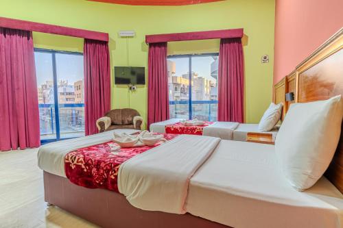 a bedroom with two beds and a large window at City Relax Hotel in Dubai