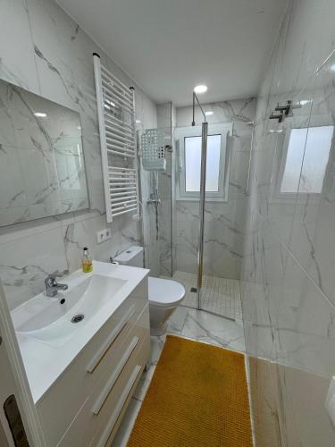 a white bathroom with a sink and a shower at Mar & Sol Spain in Empuriabrava