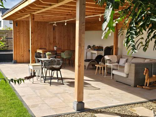 a patio with a table and chairs under a pergola at Vida Verde in Valkenburg