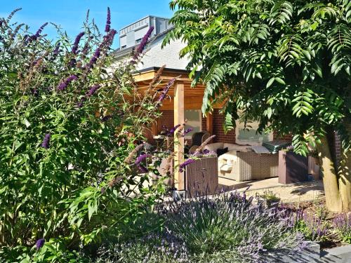 a garden with purple flowers in front of a house at Vida Verde in Valkenburg