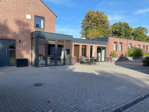 a brick building with a glass extension on it at Vida Verde in Valkenburg