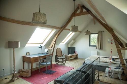 - une chambre mansardée avec un lit et un bureau dans l'établissement La Bergerie, à Fatouville-Grestain