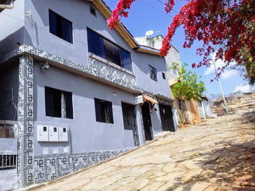 a white building on a dirt road at Hospedaria Oliveira - São Thomé das Letras in São Thomé das Letras
