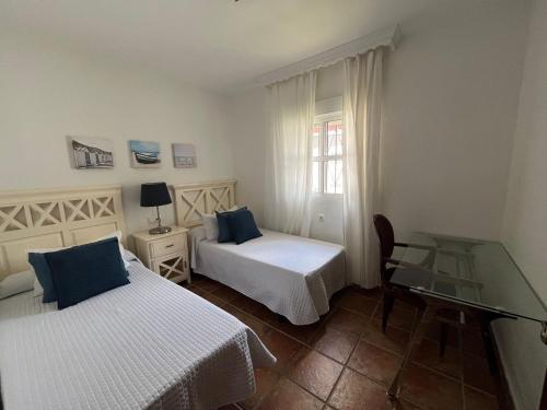 sypialnia z 2 łóżkami i szklanym stołem w obiekcie VILLA ANDEMAR w mieście Chiclana de la Frontera