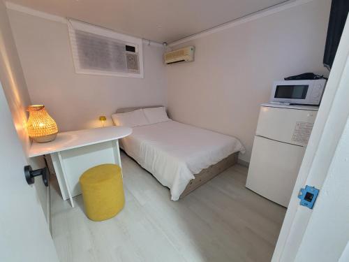 a small room with a bed and a table and a microwave at stay110 in Seoul