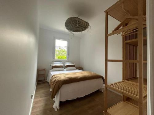 une chambre avec un lit avec deux oreillers et une échelle dans l'établissement la cabane de Maud, à Brison-Saint-Innocent