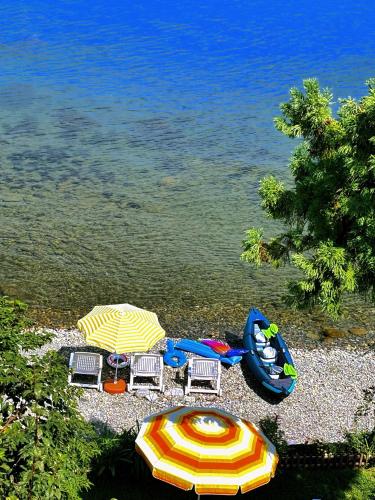 two umbrellas and chairs and a boat on a beach at Seafront Apartment Rize-Ardeşen in Ardeşen