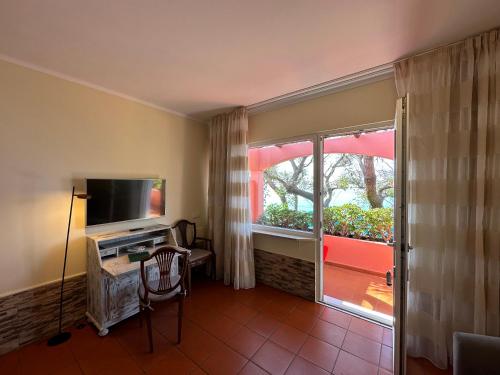 a living room with a television and a window at Inn & Art Madeira in Caniço