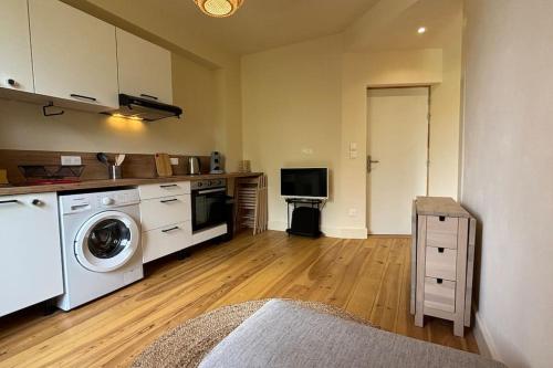 a kitchen with a washer and dryer in a room at T2 cocon avec balcon et parking in La Roche-sur-Foron