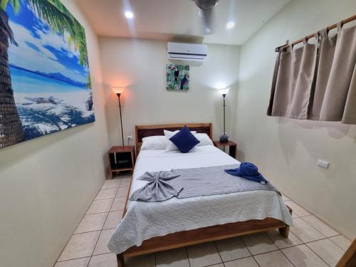 a bedroom with a bed and a painting on the wall at Pinilla Highlands Incredible mountain views in Tamarindo