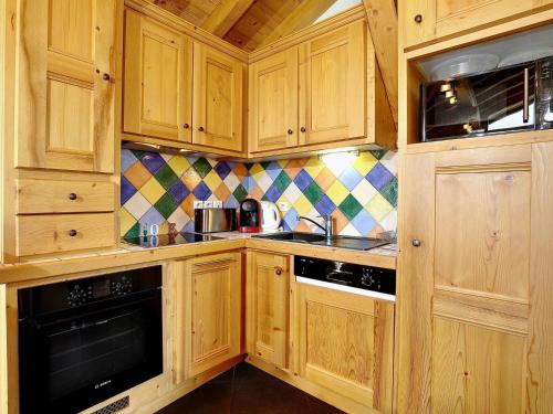 - une cuisine avec des placards en bois et une cuisinière dans l'établissement Charmant duplex 6 pers avec cheminée et garage à Courchevel - FR-1-575-194, à Courchevel