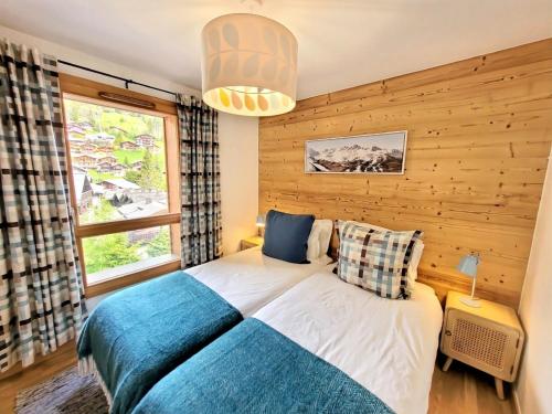 une chambre avec un lit et une fenêtre dans l'établissement Duplex 4 chambres, balcon, double garage, Les Gets - FR-1-598-166, aux Gets