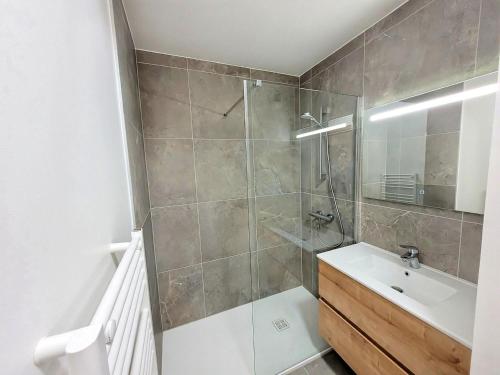 une salle de bain avec une douche avec un lavabo et un miroir dans l'établissement Duplex 4 chambres, balcon, double garage, Les Gets - FR-1-598-166, aux Gets