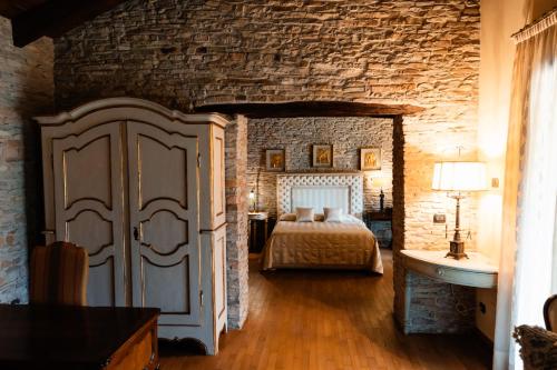 a bedroom with a bed and a brick wall at Cadgal - Tenuta La Cova in Calamandrana