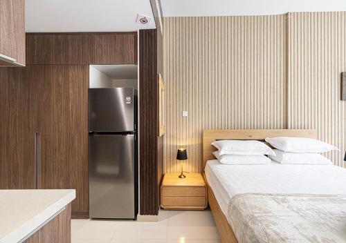 a kitchen with a bed and a refrigerator in a room at The Prestige Studio by Blue Cloud Holidays in Sharjah