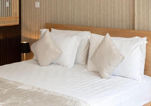 a white bed with white pillows on it at The Prestige Studio by Blue Cloud Holidays in Sharjah