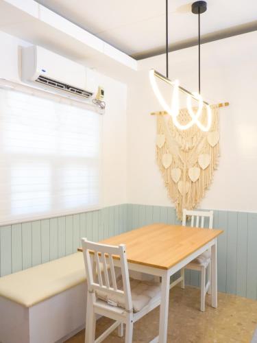 a dining room with a table and chairs and a chandelier at Urban Oasis Resort, Tarlac in Tarlac