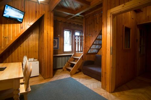 a room with wooden walls and a staircase with a desk at Willa Orla in Zakopane