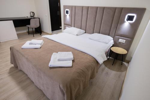 a bedroom with a large bed with towels on it at Fantasia Hotel in Polyana