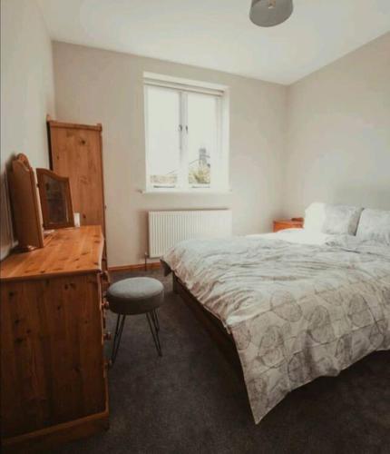 a bedroom with a bed and a desk and a window at Charming 2 Bedroom Cottage mid town on quiet road, sleeps 4 in Sudbury