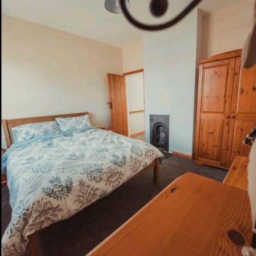 ein Schlafzimmer mit einem Bett und einem Holzofen in der Unterkunft Charming 2 Bedroom Cottage mid town on quiet road in Sudbury