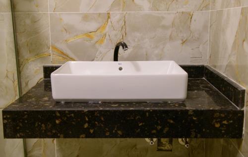 a white sink on a black counter in a bathroom at Eyaru Palace Nile View in Luxor