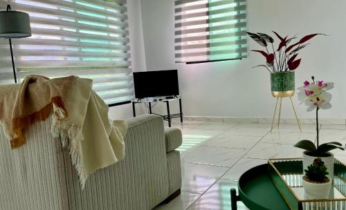 a living room with a couch and a tv at Acogedor apartamento con hermosa vista al volcán - The Goat Spot - planta alta in Alto Boquete