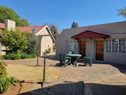 a patio with a table and chairs in front of a house at Airport Inn Bed and Breakfast in Kempton Park