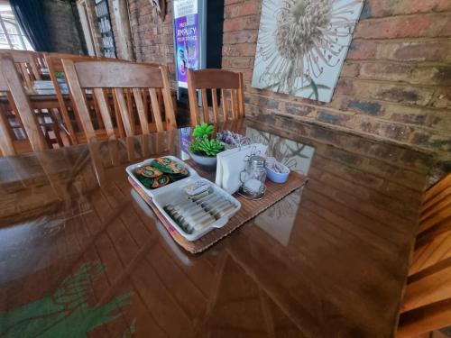 a table with a plate of food on top at Airport Inn Bed and Breakfast in Kempton Park