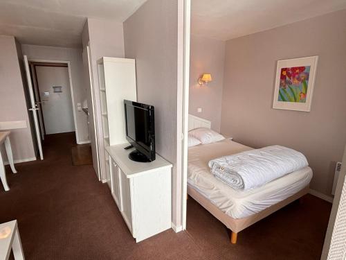 une petite chambre avec un lit et une télévision à écran plat dans l'établissement Charmant 2 pièces skis aux pieds, quartier calme, proche remontées et commerces à Morzine - FR-1-634-38, à Avoriaz