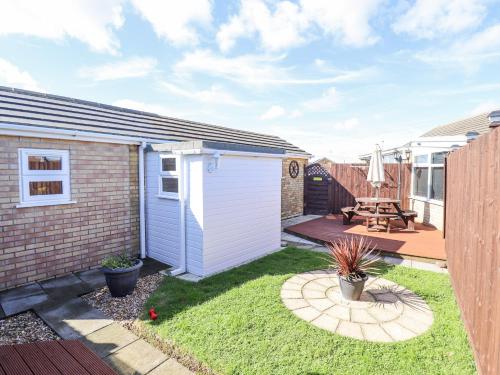 a small backyard with a shed and a patio at Lockdown Lodge in Mablethorpe