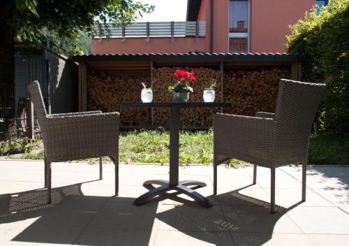 three chairs and a table with flowers on it at Charmante Ferienwohnung in bester Lage in Feldkirch