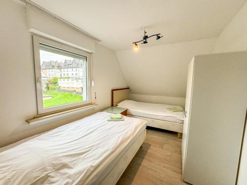 two beds in a small room with a window at Cici Monteurunterkünfte in Werdohl mit Küche, WLAN, TV, Parken in Werdohl