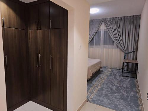 a bedroom with a large wooden cabinet next to a bed at The Room of Dream in Ajman