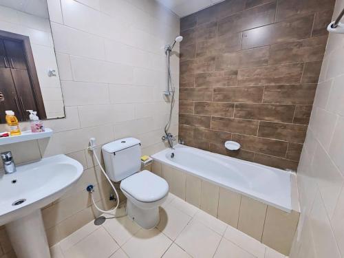 a bathroom with a toilet and a sink and a tub at The Room of Dream in Ajman