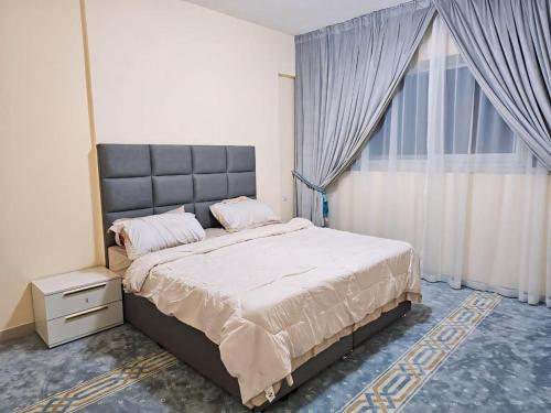 a bedroom with a large bed and a large window at The Room of Dream in Ajman
