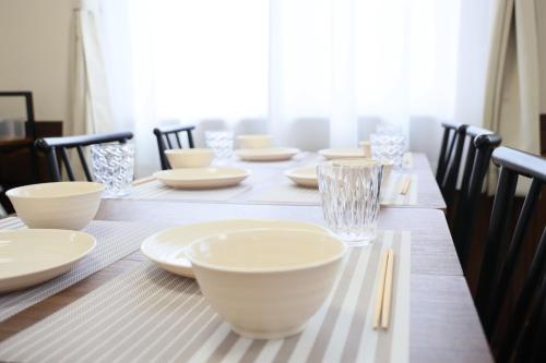 a long table with white plates and chopsticks on it at Kasugai - House - Vacation STAY 17754 in Kasugai