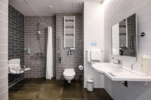 a bathroom with a sink and a toilet and a shower at Holiday Inn Express Lublin by IHG in Lublin