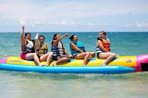 a group of people sitting on a raft in the water at Studio Seaview Jomtien floor12 23sqm in Jomtien Beach