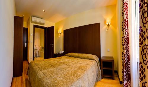 a bedroom with a large bed in a room at Hotel Duas Nações in Lisbon