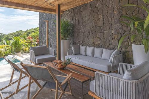 a patio with a couch and chairs and a table at Stella Mar Ocean view in Santa Teresa Beach