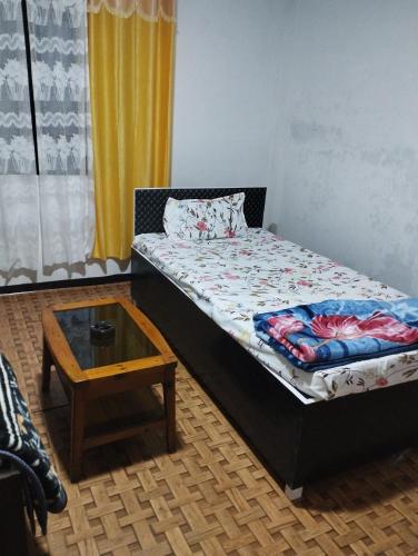 a small bedroom with a bed and a table at Sunset View Guest House in Cherrapunji