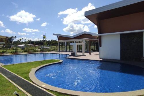 ein großes Schwimmbad vor einem Gebäude in der Unterkunft Luxa House Staycation Tagaytay in Panungyanan