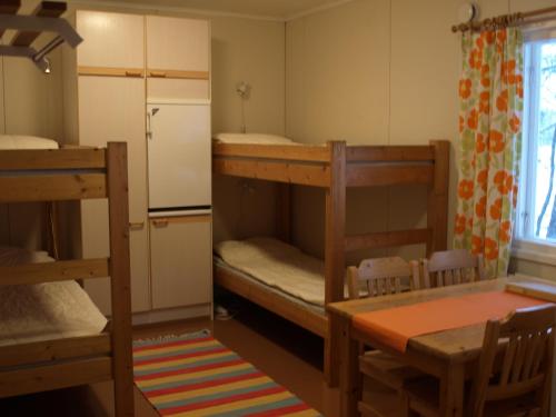a room with two bunk beds and a table at Koirasalmen Luontotupa in Kivijärvi