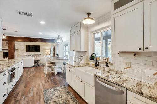 a kitchen with white cabinets and a dining room at Your Rustic Retreat w Backyard Oasis Pool Patio in Keller